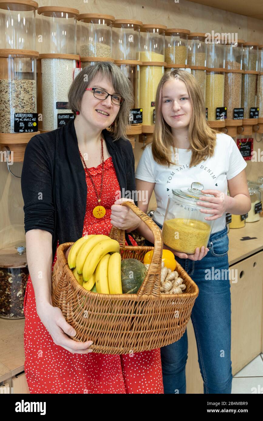 Eine Frau und eine Schülerin stehen vor einem Regal mit Abfüllbehältern für Getreide im verpackungsfreien Laden „Frau Erna`s loser LebensMittelpunkt“ Stock Photo
